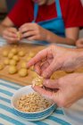 Mains travaillant avec la pâte et la pâtisserie décorative — Photo de stock
