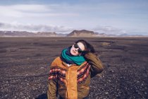 Smiling human with standing between dark grounds in Iceland — Stock Photo