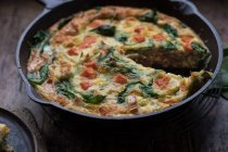 Plate and frying pan with frittata — Stock Photo