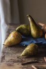 Fresh pears on blue napkin on lumber table in kitchen — Fotografia de Stock