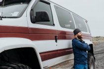 Adulto barbudo homem de pé com confiança com o braço cruzado perto enorme off roader na estrada remota, Islândia — Fotografia de Stock