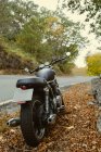 Кафе гонщик мотоцикл припаркований на дорозі в осінній сільській місцевості — стокове фото