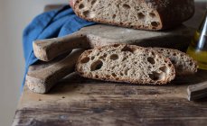 Кусочки свежего цельнозернового хлеба камута с пивом на деревянном столе — стоковое фото