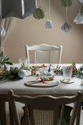 Feriado celebração mesa configuração, em cores brancas e douradas, com decorações penduradas decorar a mesa — Fotografia de Stock