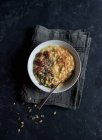 Oatmeal porridge with turmeric in bowl on dark background — Stock Photo