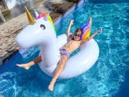 Boy swimming on unicorn float — Fotografia de Stock