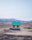 Colourful house on brown field between death lands and stone hills in Iceland — Stock Photo