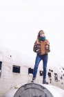 Giovane signora vestita con abiti caldi su aerei rotti tra terreni bui in Islanda — Foto stock