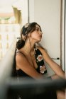 Мрійлива молода леді в елегантній сукні сидить на балконі — стокове фото