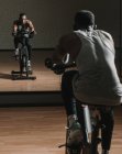 Black guy making selfie on exercise bike in gym — Stock Photo