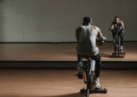 Black guy making selfie on exercise bike in gym — Stock Photo