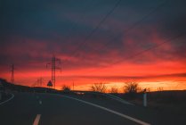 Estrada da estrada rural durante o pôr-do-sol com céu dramático — Fotografia de Stock