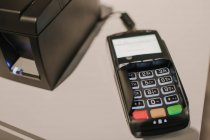 Closeup shot of modern payment terminal lying on counter in modern store — Stock Photo