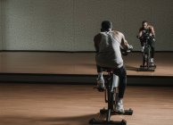 Чорний хлопець робить селфі на тренувальному велосипеді в тренажерному залі — стокове фото