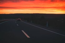 Véhicules conduisant le long de la route de campagne au coucher du soleil dans le Cap des Pois, Asturies — Photo de stock