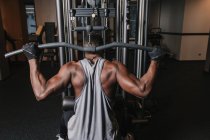 Black man exercising on machine in gym — Stock Photo