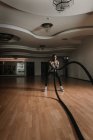 Negro chico ejercitando con cuerdas en gimnasio - foto de stock