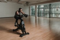 Чорний хлопець робить селфі на тренувальному велосипеді в тренажерному залі — стокове фото