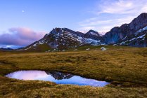 Vista mozzafiato del piccolo lago con acqua pulita situato vicino a belle montagne verdi sul clima nuvoloso in campagna nelle Asturie, Spagna — Foto stock