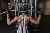 Black man exercising on machine in gym — Stock Photo