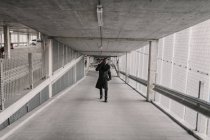 Uomo afroamericano in abito elegante camminare nel passaggio di edificio moderno e avere conversazione smartphone — Foto stock