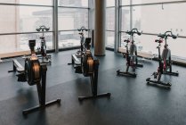 Máquinas de exercício perto de enorme janela no ginásio — Fotografia de Stock