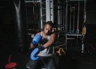 Black man putting on boxing gloves — Stock Photo