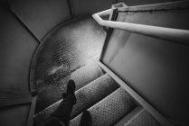 Piernas de persona anónima de pie en una escalera de caracol metálica dentro de la cárcel en Oviedo, España - foto de stock