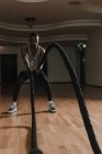 Nero ragazzo esercizio con corde in palestra — Foto stock