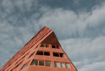 From below modern abstract red facade of block of flats and cloudy heaven in Pyrenees — Stock Photo