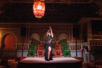Jeune femme en robe dansant le flamenco sur scène dans une chambre orientale luxueuse décorée de mosaïque — Photo de stock