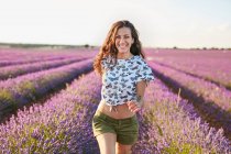 Молода жінка біжить між фіолетовим лавандовим полем — стокове фото