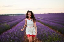 Молода жінка біжить між фіолетовим лавандовим полем — стокове фото