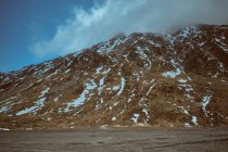 Nuage sur la montagne rocheuse couverte de neige — Photo de stock