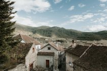 Vista panoramica della città antica vicino ad alte colline con foresta e cielo blu con nuvole nei Pirenei — Foto stock