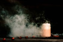Fume branco fino espalhando-se sobre mesa com jarra de café fresco e especiarias aromáticas — Fotografia de Stock