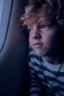 Cute boy with headphones in plane — Stock Photo
