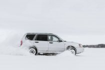 Автомобіль, що їде на сніговому полі — стокове фото