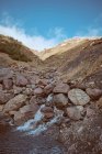 Petit ruisseau sur une colline pierreuse en montagne — Photo de stock