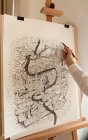 Mulher com lápis pintando cidade em papel grande — Fotografia de Stock