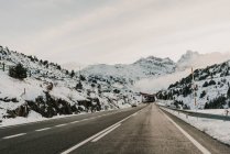 Rota nevada que corre entre montanhas em Pirinéus — Fotografia de Stock