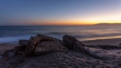 Increíble costa rocosa de mar tranquilo durante el magnífico atardecer - foto de stock