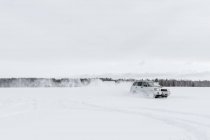 Auto fährt auf Schneefeld — Stockfoto