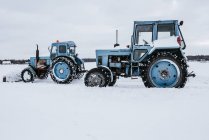 Seitenansicht von Traktoren beim Schneeräumen von Wiesen in Vilnius, Litauen — Stockfoto