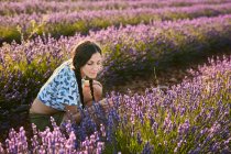 Привлекательная девушка, пахнущая красивыми фиолетовыми цветами на лавандовом поле — стоковое фото