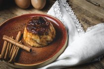 Вкусный домашний пудинг на тарелке на деревенском деревянном столе — стоковое фото