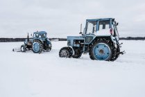 Traktoren räumen Schnee vom Feld — Stockfoto