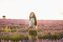 Sorrindo jovem mulher girando no campo de lavanda violeta grande — Fotografia de Stock
