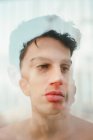 Double exposure of brunette shirtless young guy looking away on blurred background — Stock Photo