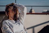 Attraktive Frau sitzt auf Dach — Stockfoto